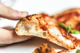 mano agarrando pizza napolitana